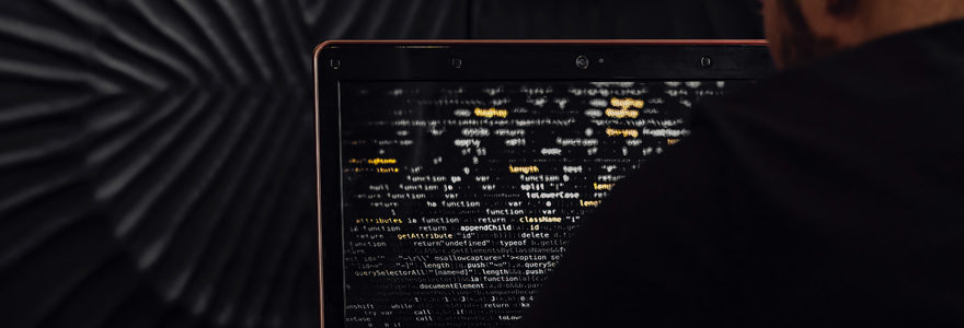 Homme écrivant du code sur un ordinateur portable